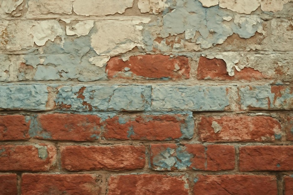 Close-up of layered paint and brick on an old storefront